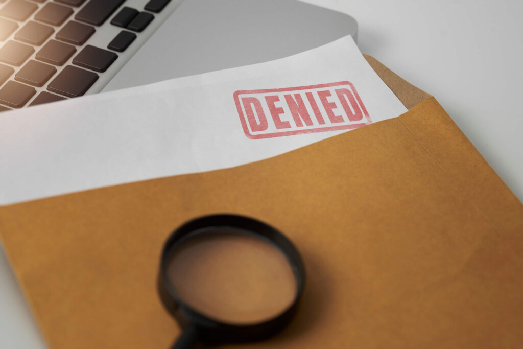 Document with a denied stamp Document with a denied stamp and magnifying glasses